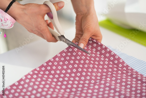 Closeup on seamstress cutting fabric photo