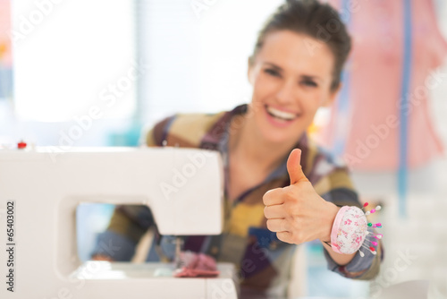 Closeup on seamstress with sewing machine showing thumbs up