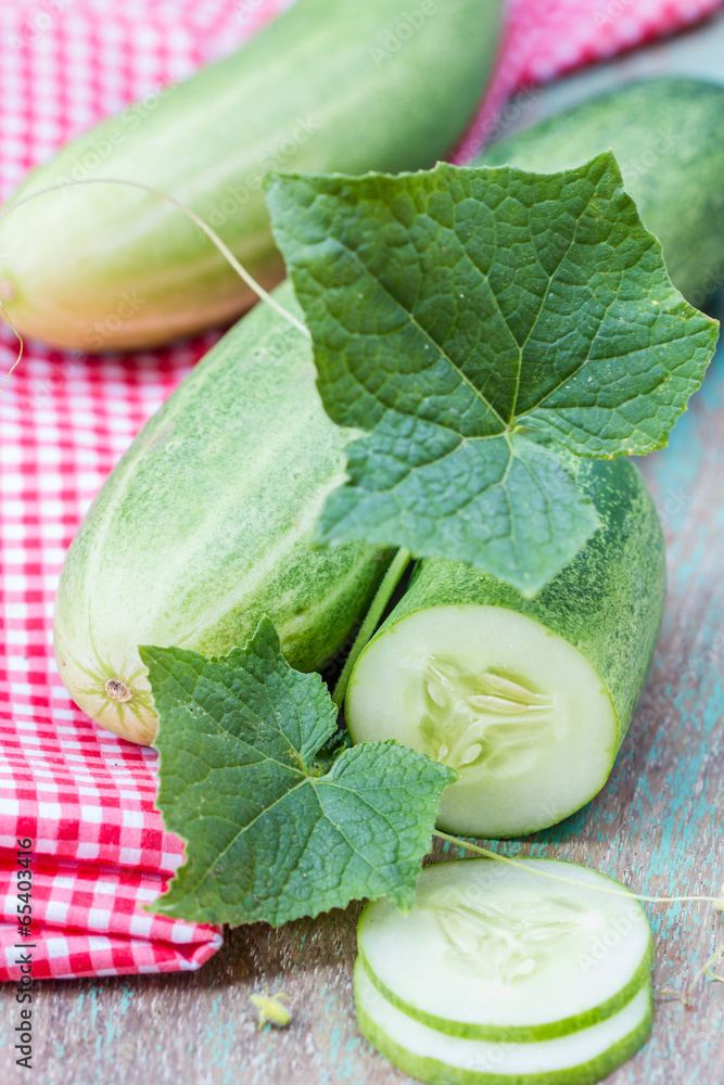 Green cucumbers and slices on a wooden background Green cucumbers and slices on a wooden background
