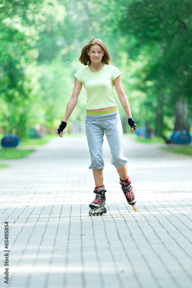 Roller skating sporty girl in park rollerblading on inline skate Roller skating sporty girl in park rollerblading on inline skate