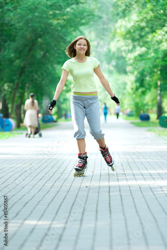 Roller skating sporty girl in park rollerblading on inline skate