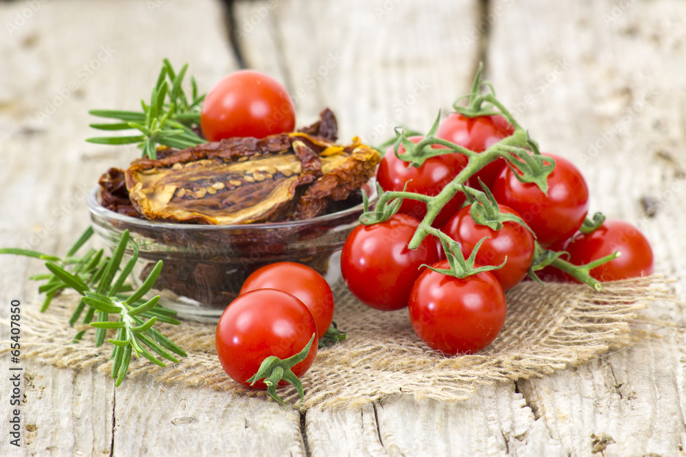 fresh and dried tomatoes on wooden background