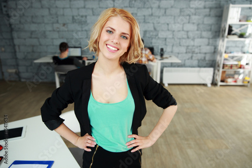 Happy businesswoman standing in office