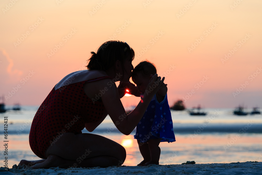 mother and daughter on sunset beach