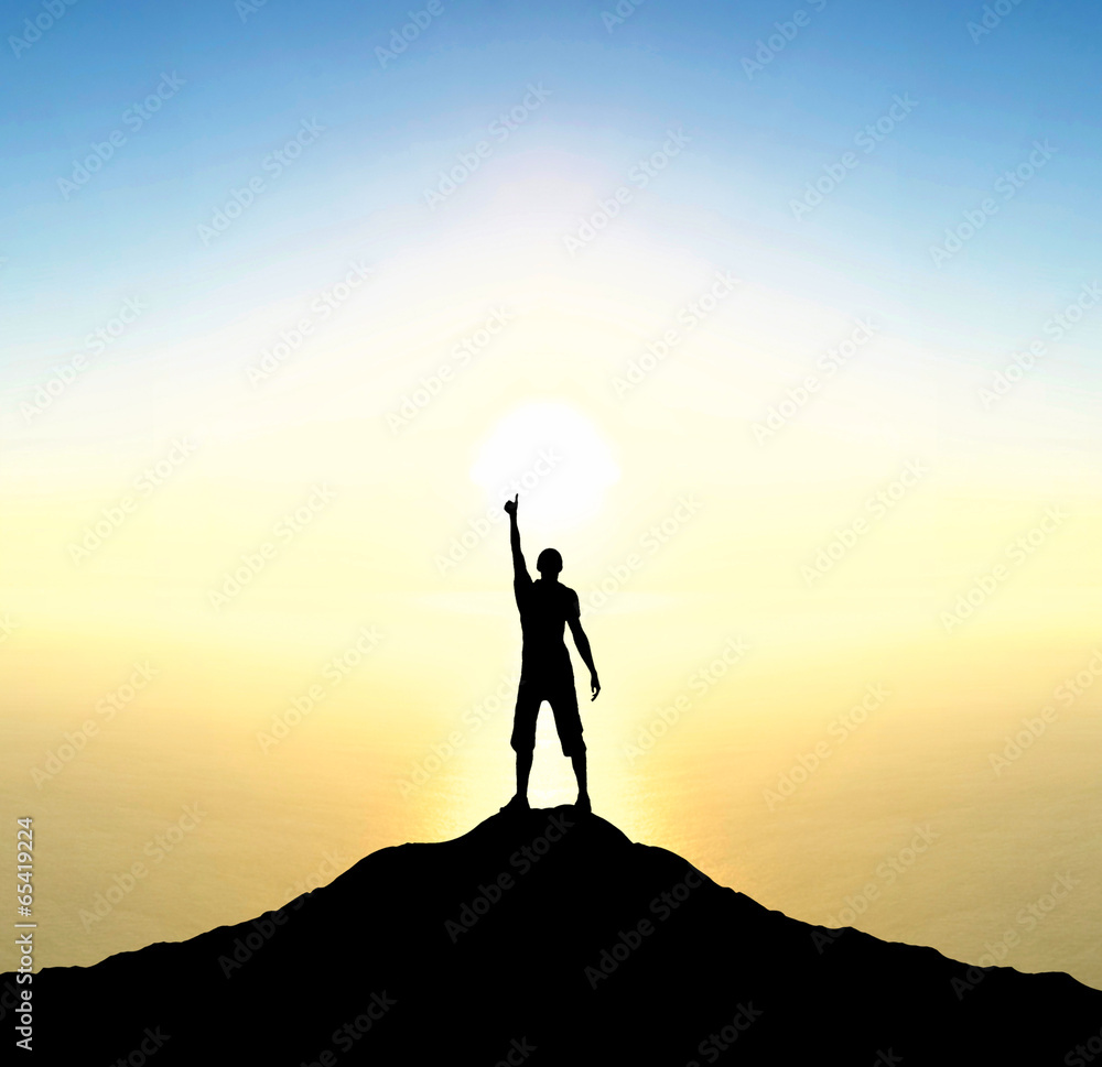 Fototapeta premium Champion on mountain peak during sunrise