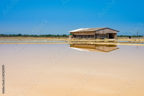 Dunaliella salina in salt evaporation pond and wooden storehouse photo