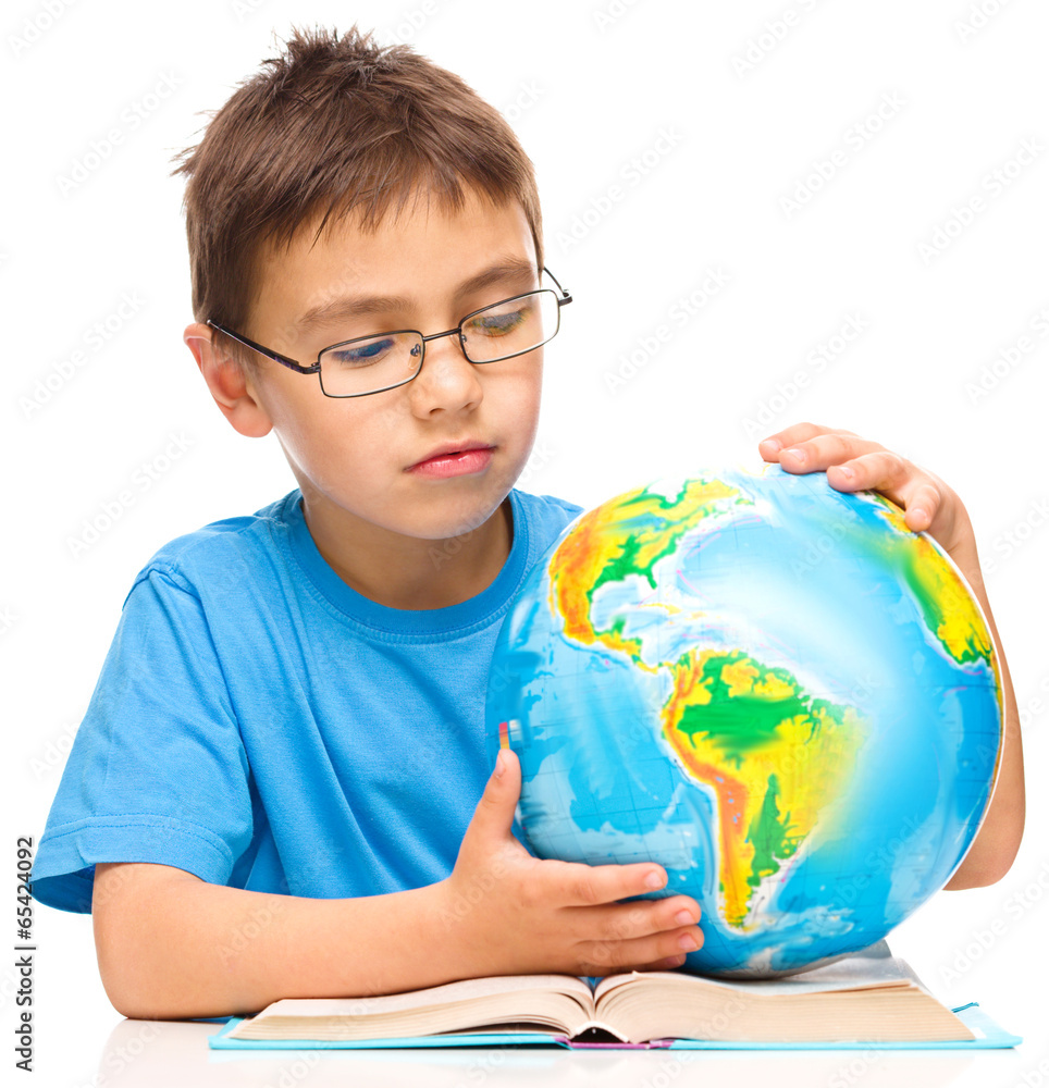 Little boy is examining globe Little boy is examining globe