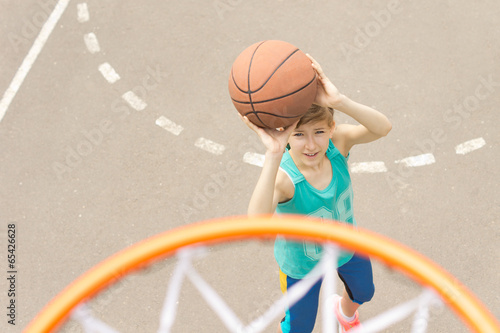 Teenage girl playing basketball © kolotype