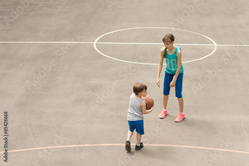 Young boy and girl playing basketball