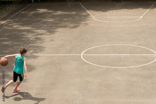 Obraz na płótnie Energetic teenage girl playing basketball w salonie