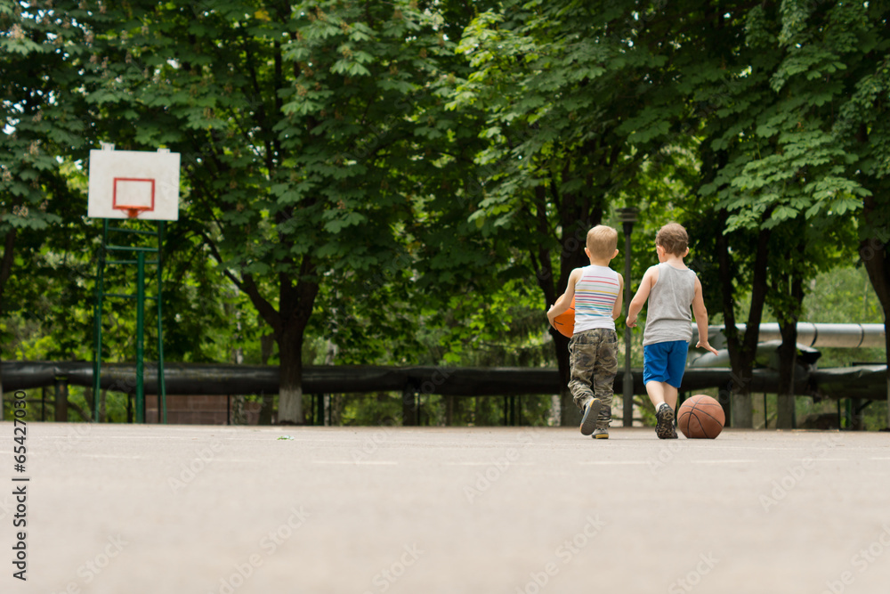 Two young boys walking off a basketball court