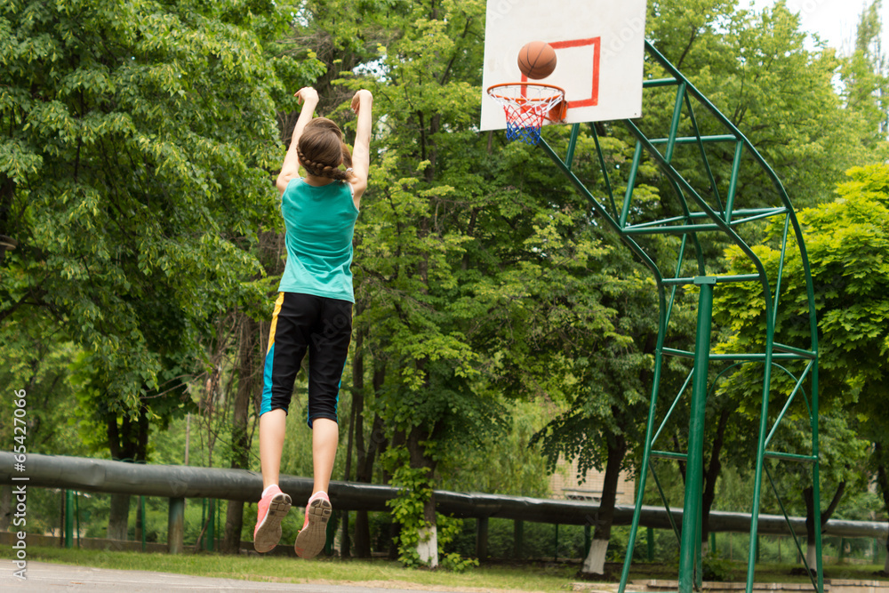 Skilled young basketball player shooting a goal