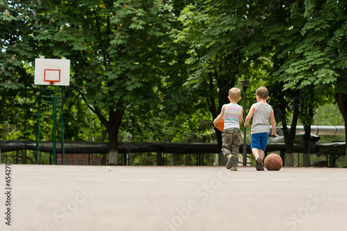 Obraz na płótnie Two young boys walking off a basketball court w salonie