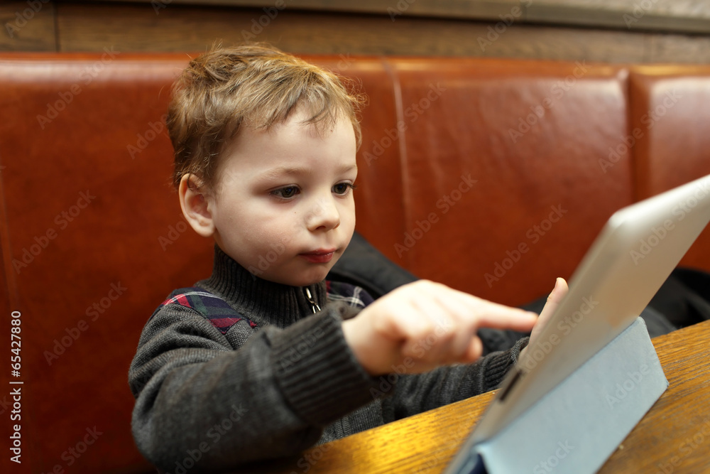 Boy playing on a Tablet PC Boy playing on a Tablet PC