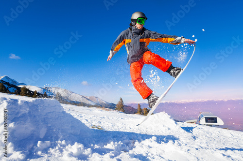 Snowboarder holding board during jump