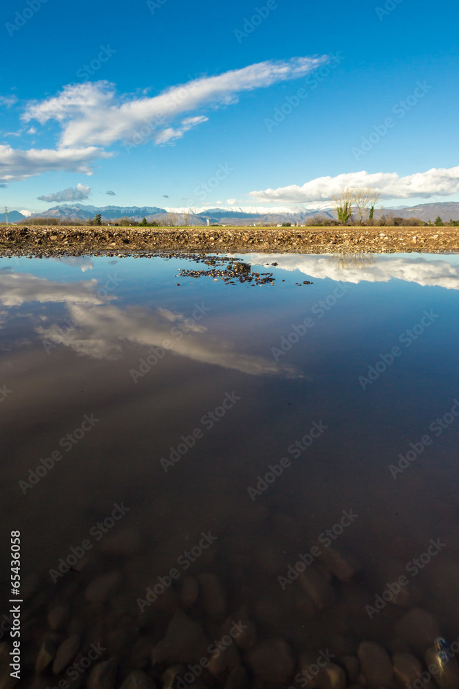 Reflection of sunny afternoon in the puddle