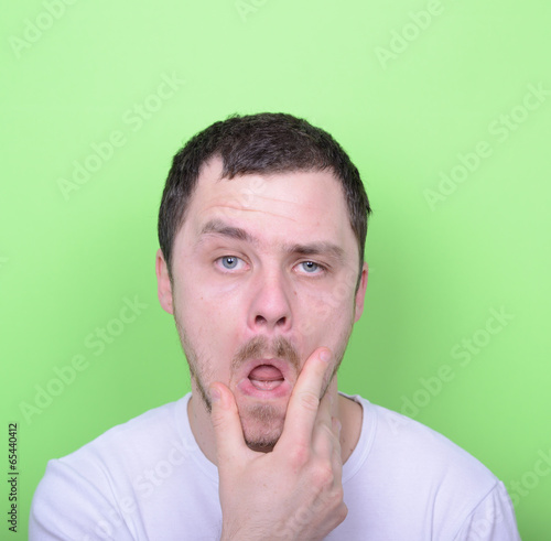 Portrait of funny cluelles man against green background