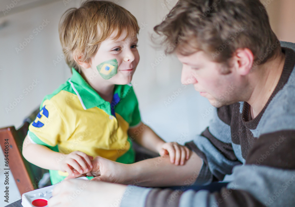 Father painting flag on face of little son Father painting flag on face of little son