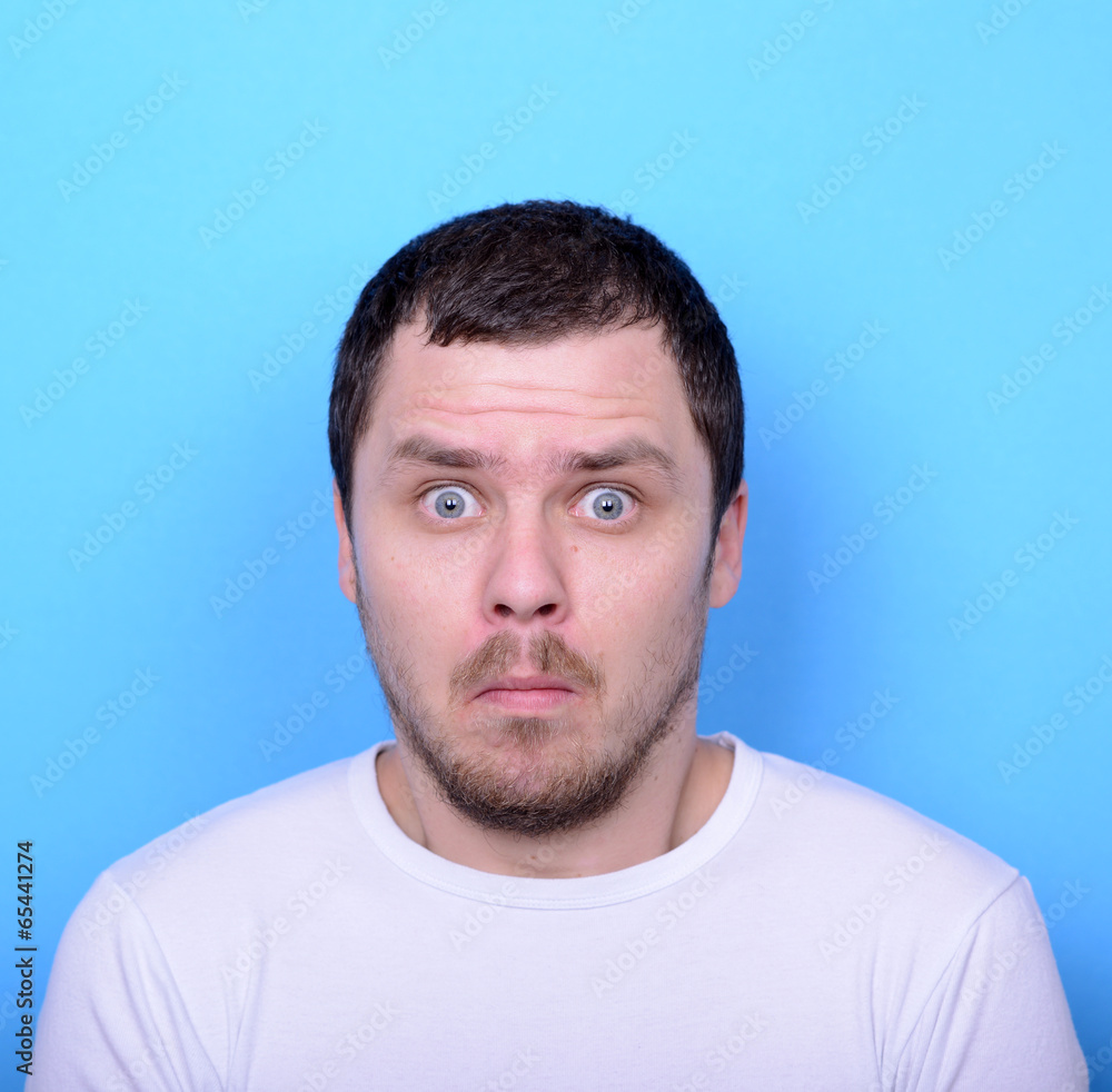 Portrait of man with dusgusted gesture against blue background Portrait of man with dusgusted gesture against blue background