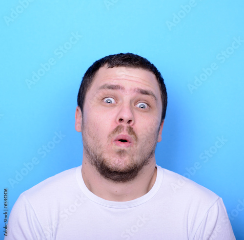 Portrait of man with funny face against blue background
