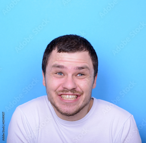 Portrait of man with funny face against blue background