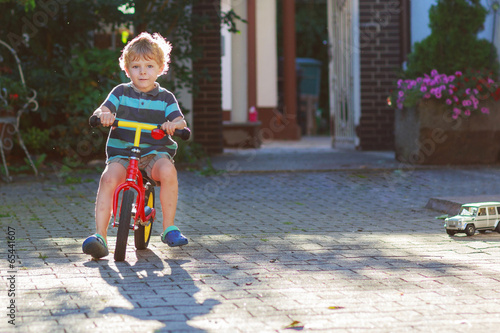 Fototapeta Naklejka Na Ścianę i Meble -  Little toddler boy of 3 years having fun on his  bicycle