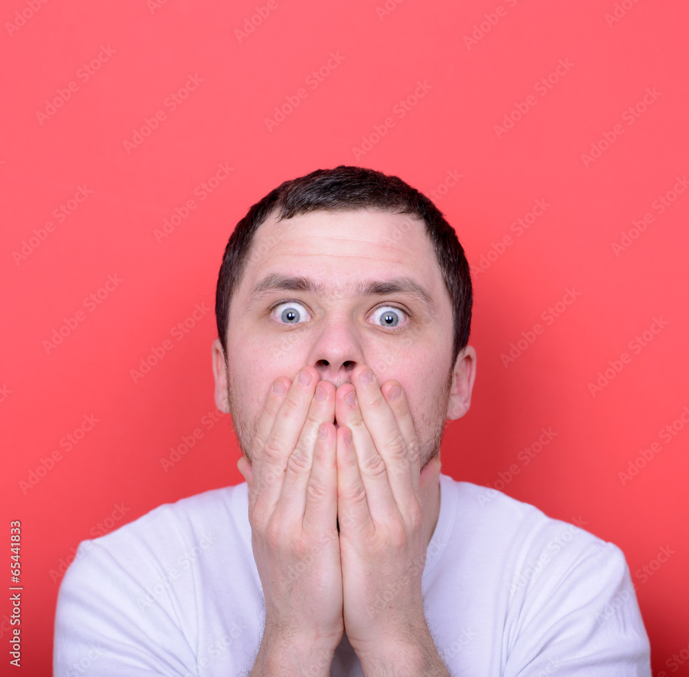Portrait of man with hands covering mouth against red background Portrait of man with hands covering mouth against red background