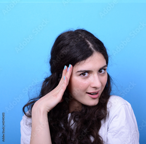 Portrait of girl with shock gesture looking up against blue back