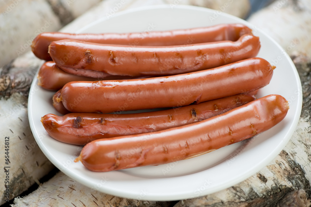 Grilled sausages on a glass plate, horizontal shot Grilled sausages on a glass plate, horizontal shot