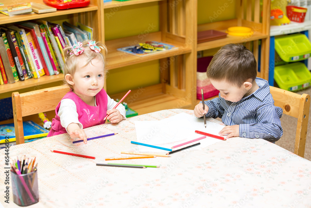 Two little kids drawing with colorful pencils in preschool Two little kids drawing with colorful pencils in preschool