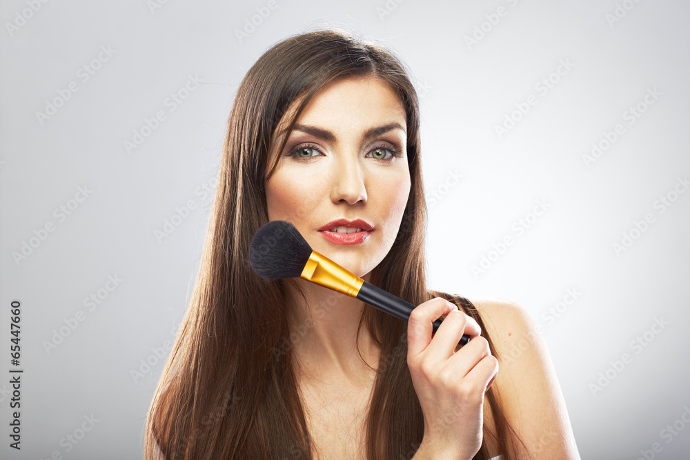 Beauty woman applying face make up with brush.