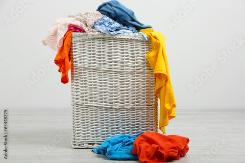 Cuadro en lienzo Full laundry basket  on wooden floor on gray background