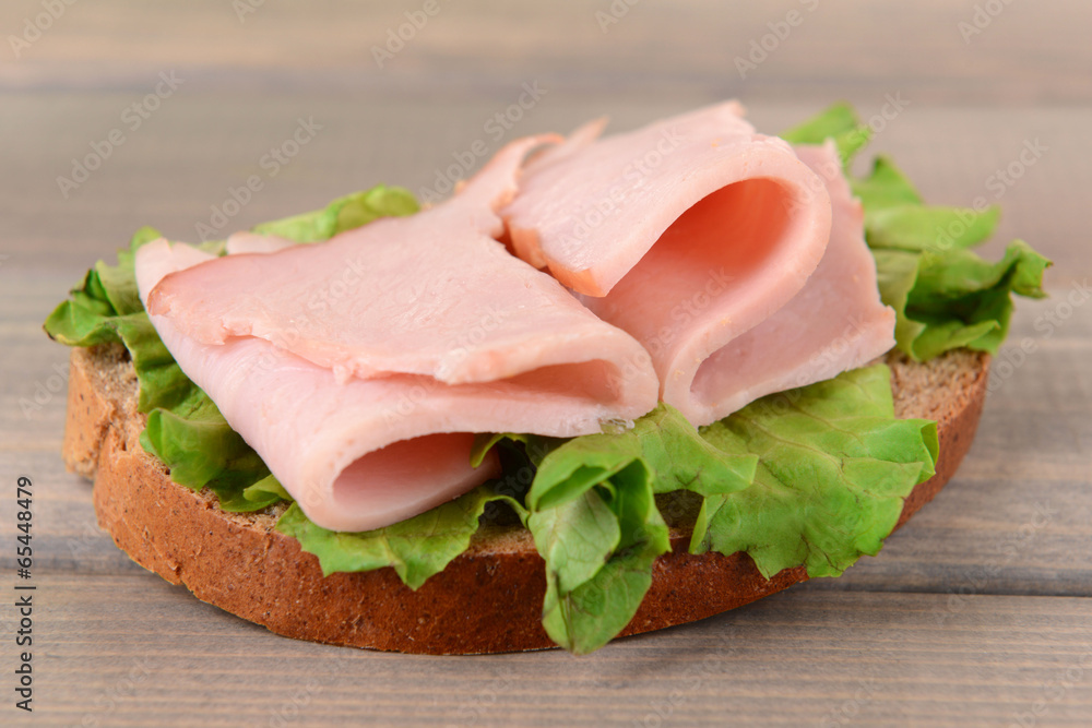 Delicious sandwich with lettuce and ham on table close-up Delicious sandwich with lettuce and ham on table close-up