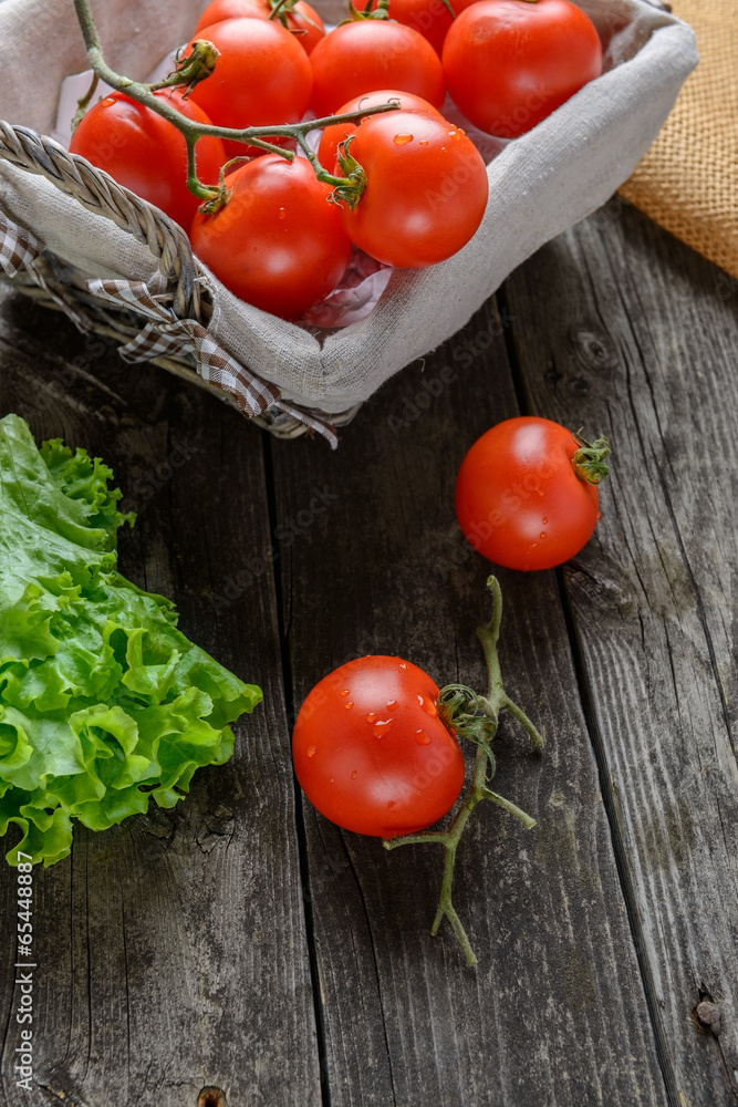 Tomatoes and salad on old grey wood