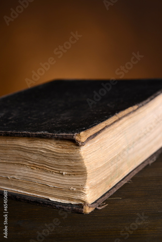 Old book on table on brown background