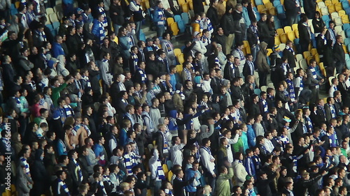 Fans in scarfs shout for playing team, stadium arena supporters