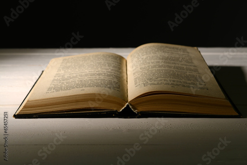Old book on table on black background