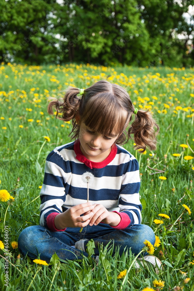 Little girl with dandelion on the green lawn Little girl with dandelion on the green lawn