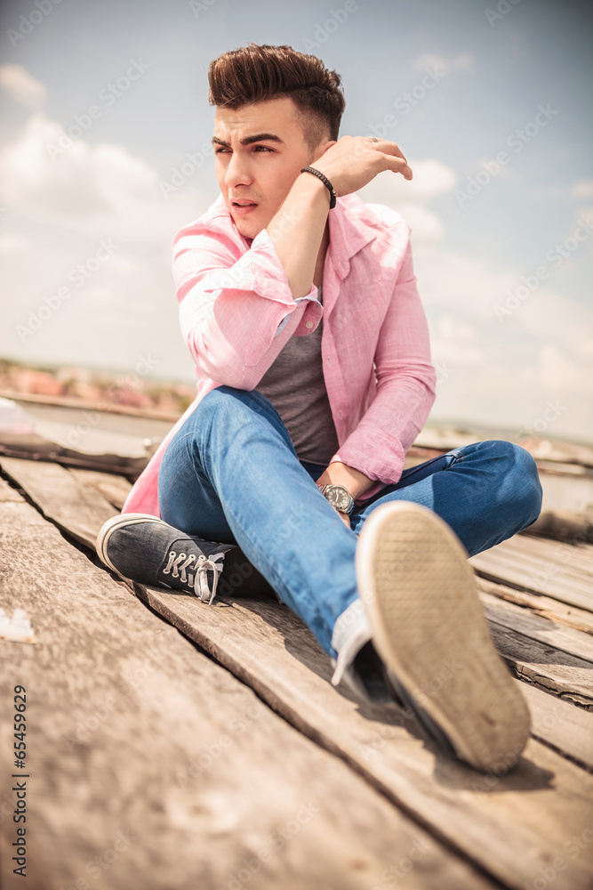 relaxed young fashion man sitting outdoor