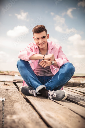 laughing young man sitting on the floor