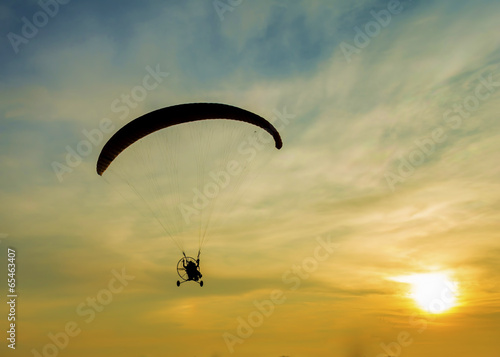 Silhouette paramotor in sunset.