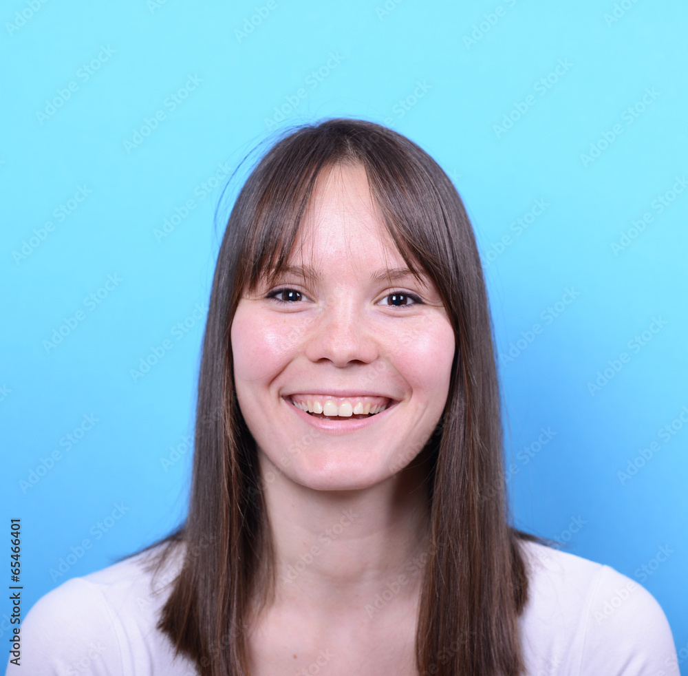 Portrait of beautiful woman with hge smile against blue backgrou Portrait of beautiful woman with hge smile against blue backgrou