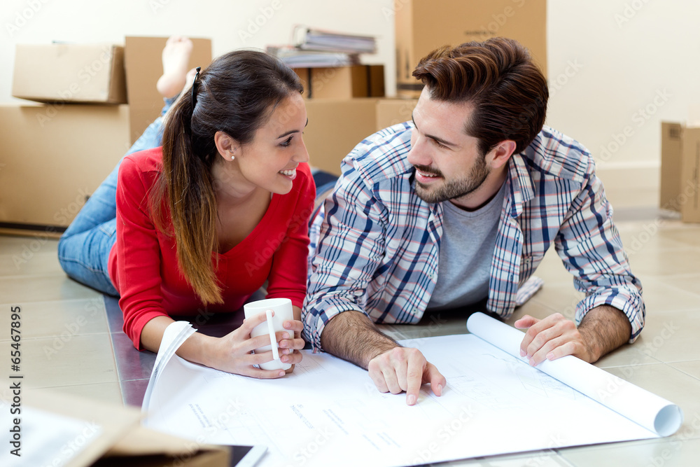 Young couple looking at the blueprints of their new home Young couple looking at the blueprints of their new home