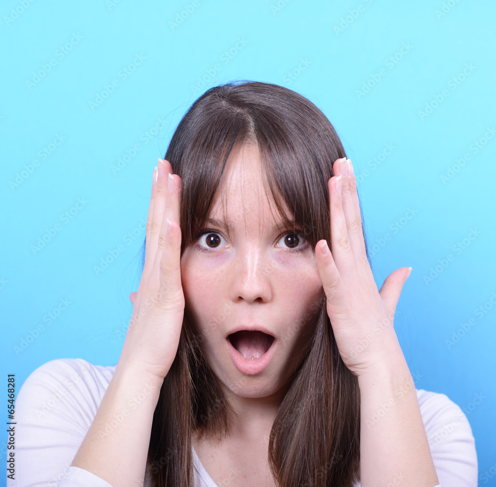 Portrait of girl with shock gesture against blue background Portrait of girl with shock gesture against blue background