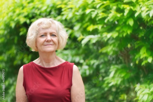 Mature, blonde woman in garden,