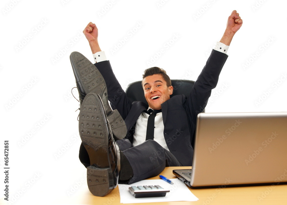 Happy young businessman in suit at the computer Happy young businessman in suit at the computer