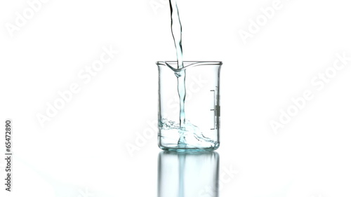 Blue liquid pouring into beaker photo