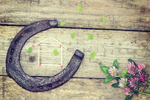 old horseshoe with clover on wooden background.