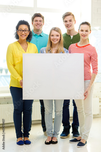 smiling students with white blank board at school © Syda Productions