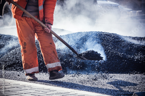 Fotografie Workers making asphalt with shovels at road constructio